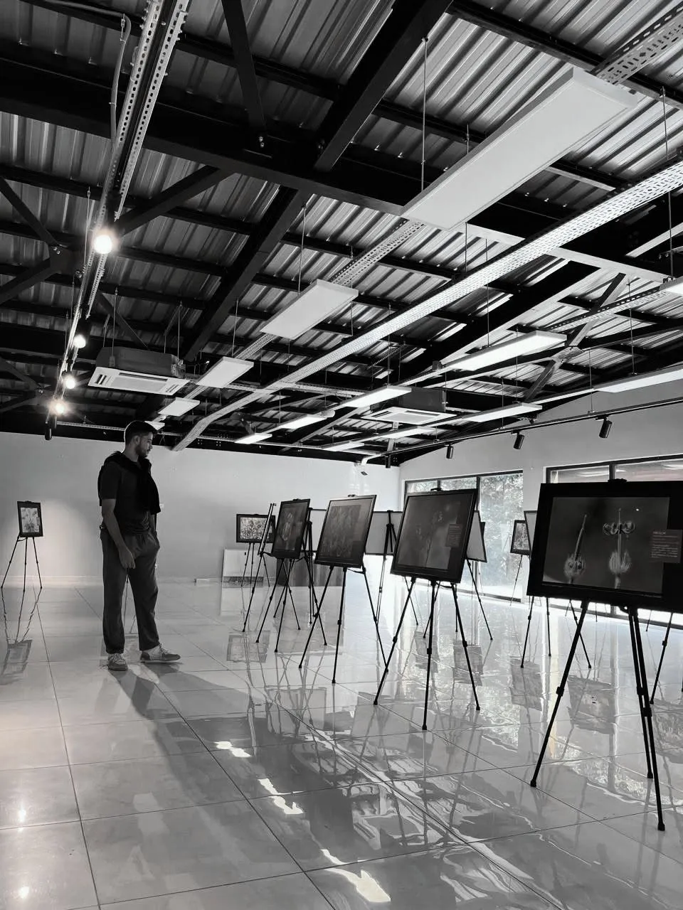 Aziz Mrad walking through a photography exhibition of framed macro prints