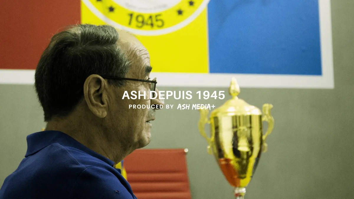An elderly club elder in profile beside a gold trophy, under the ASH Depuis 1945 title card
