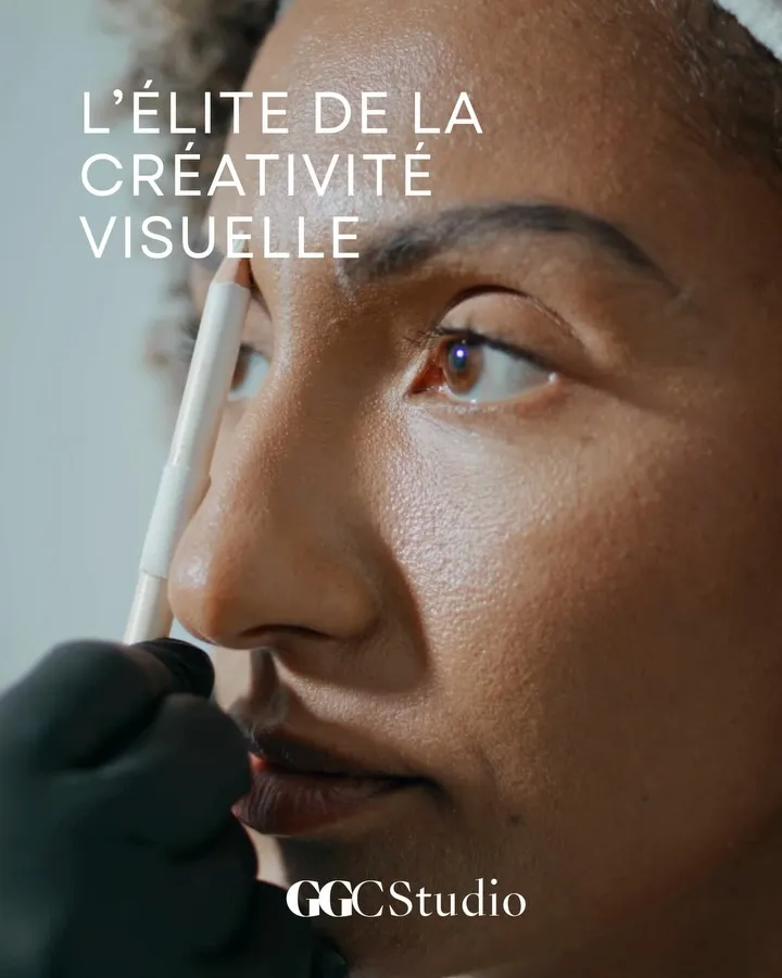 Close-up of a woman's face as a practitioner marks her brow, under the line L'élite de la créativité visuelle